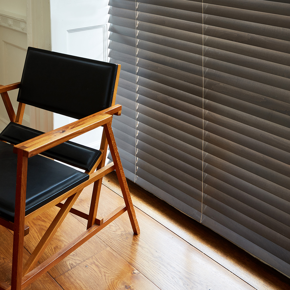 Dark grey wooden blind teamed with retro black leather chair.